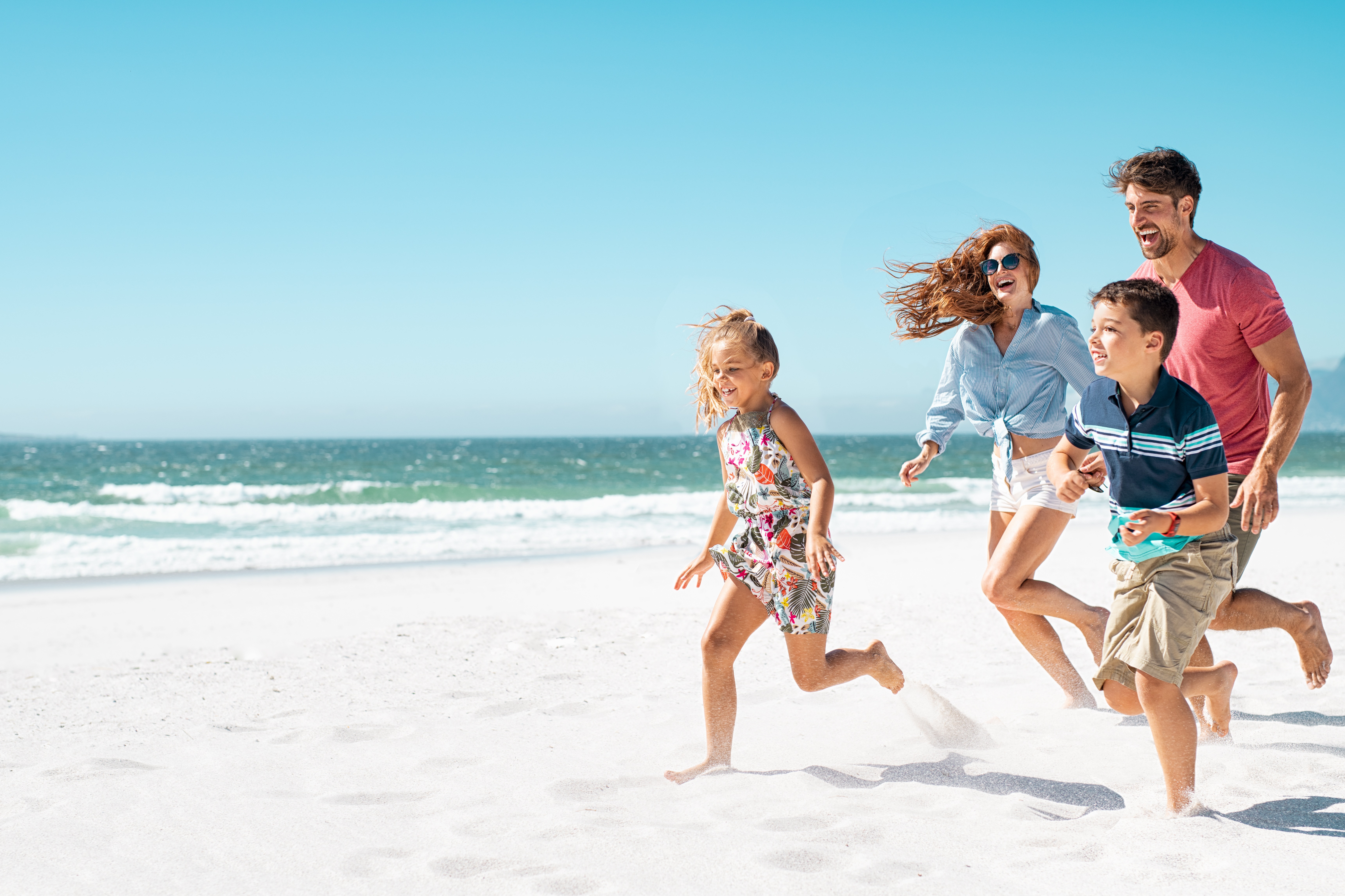 Glückliche Familie läuft am Strand