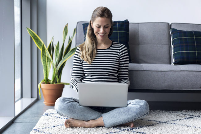 Frau mit Laptop im Wohnzimmer