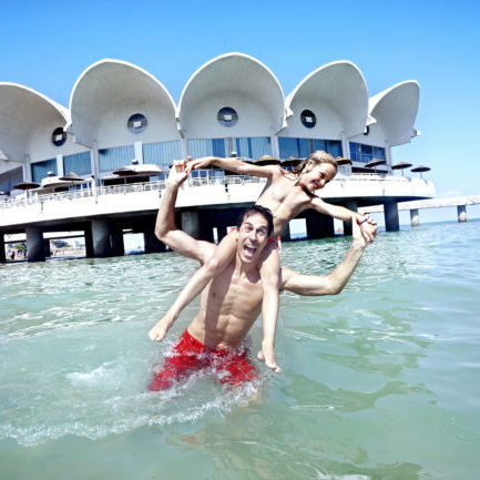 Vater und Kind im Meer in Lignano in Italien